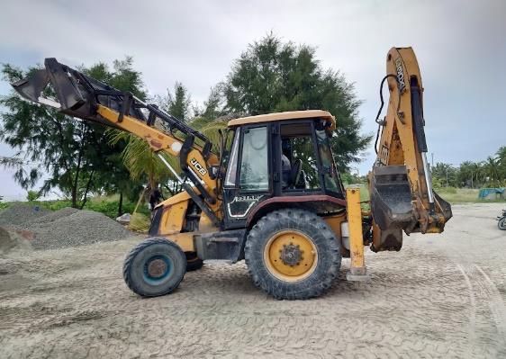 Backhoe loader on a coral sand road
