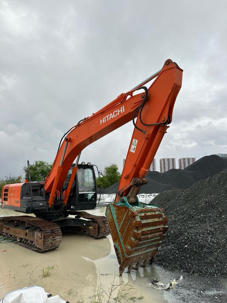 High-bed tracked excavator among palms