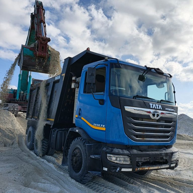 Tipper truck loading beside an excavator